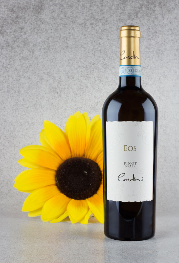 Fotografia professionale di bottiglia di vino e composizione floreale